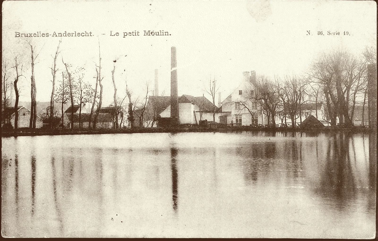 Carte postale ancienne «&nbsp;Bruxelles-Anderlecht, le petit Moulin&nbsp;» : l’étang du Petit Moulin, des arbres nus et une haute cheminée d’usine sur la rive