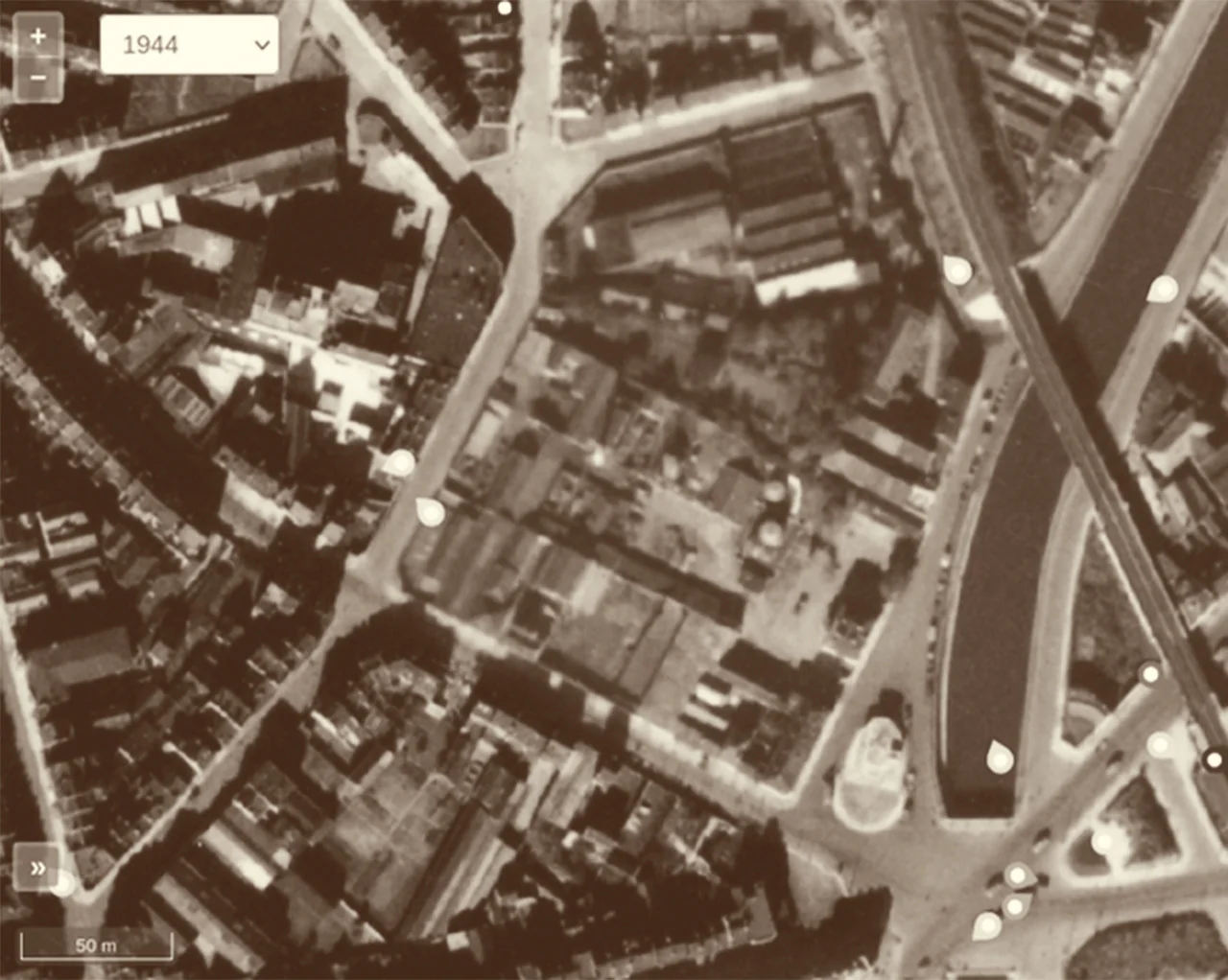 Vue aérienne de 1944 : le site du futur îlot Shell encore occupé par des ateliers et des jardins, le canal et la voie ferrée à droite