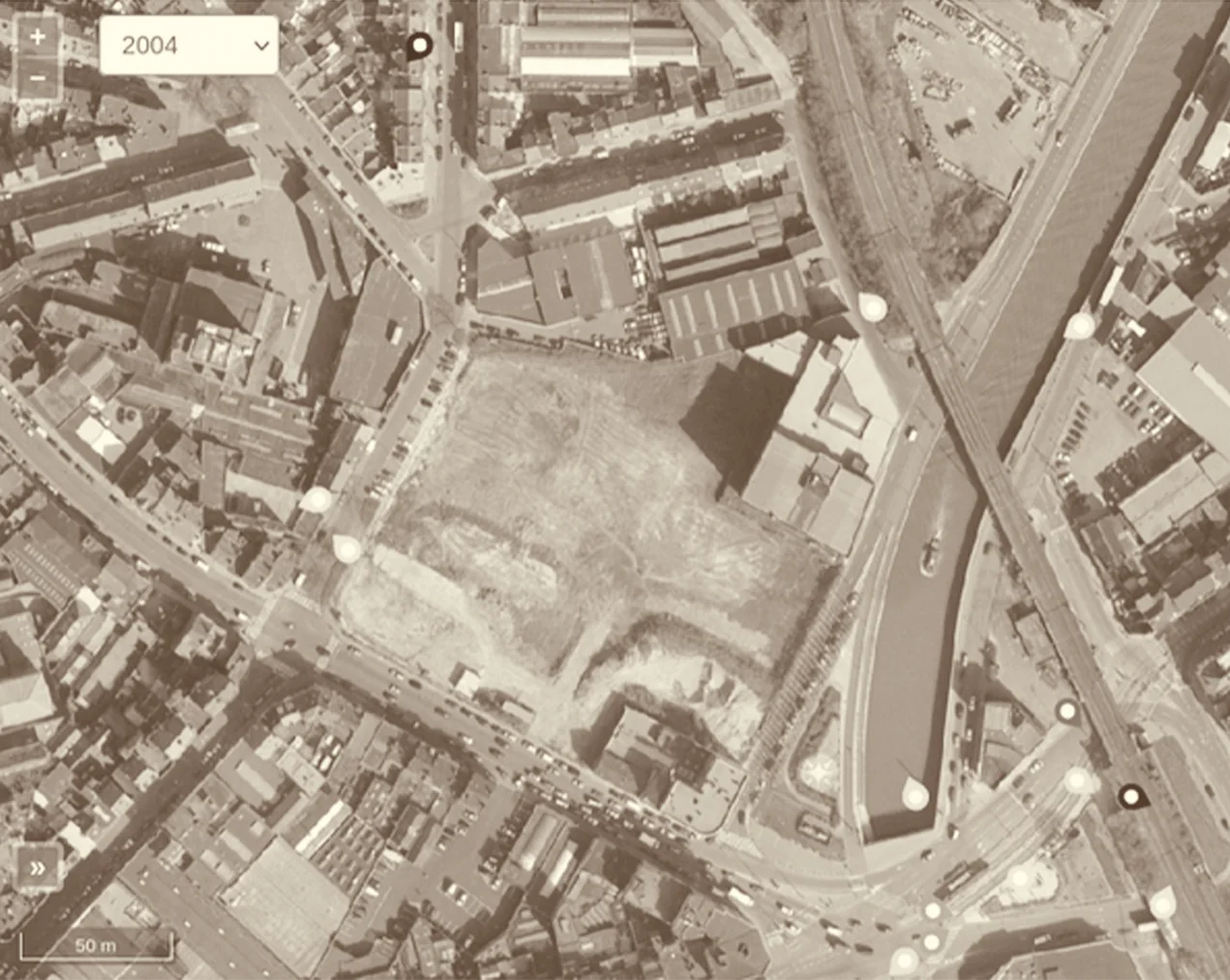 Vue aérienne de 2004 : l’îlot Shell rasé, un grand terrain nu entre les rues et le canal